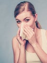 Sick woman using paper tissue, headcold problem