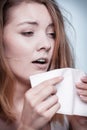 Sick woman using paper tissue, headcold problem