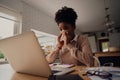 Sick woman working from home while blowing nose due to virus with cold and cough Royalty Free Stock Photo