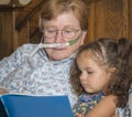 Woman wearing oxygen reads to child Royalty Free Stock Photo