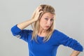 Sick young blond woman with bags scratching her hair Royalty Free Stock Photo