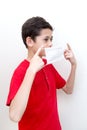 Sick young boy clutches his throat with face mask on. Royalty Free Stock Photo