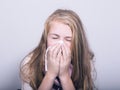 Sick young girl blowing her nose with paper tissue Royalty Free Stock Photo