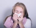 Sick young girl blowing her nose with paper tissue Royalty Free Stock Photo