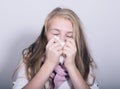 Sick young girl blowing her nose with paper tissue Royalty Free Stock Photo
