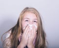 Sick young girl blowing her nose with paper tissue Royalty Free Stock Photo