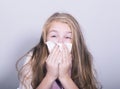 Sick young girl blowing her nose with paper tissue Royalty Free Stock Photo