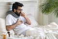 Sick Young Indian Man Coughing While Sitting In Bed At Home Royalty Free Stock Photo