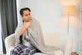 Sick young indian man suffering throat ache while sitting on bed at home Royalty Free Stock Photo