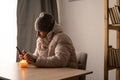 Sick young man feel cold wearing at warm clothes watching movie on smartphone, annoyed guy shiver freezing warming at Royalty Free Stock Photo