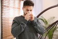 Sick young man sneezing at home. Influenza virus Royalty Free Stock Photo