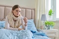 Sick young woman with in hands sitting at home on bed Royalty Free Stock Photo