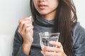 Sick young woman taking pill and drink water at home Royalty Free Stock Photo