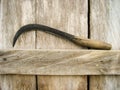 Sickle on wooden background. Sickle for the harvest of grain in asia Royalty Free Stock Photo