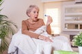 Sickness, seasonal virus problem concept. Senior woman being sick having flu lying on sofa looking at temperature on thermometer. Royalty Free Stock Photo