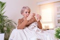 Sickness, seasonal virus problem concept. Senior woman being sick having flu lying on sofa looking at temperature on thermometer. Royalty Free Stock Photo