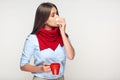 Sickness woman holding red cup blow up nose in paper tissue. Royalty Free Stock Photo