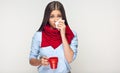 Sickness woman holding red cup blow up nose in paper tissue. Royalty Free Stock Photo