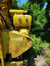 Side of an abandoned and rusting industrial yellow machine