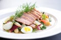 side angle of a nicoise salad, showing layered ingredients