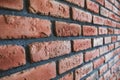 Side angle of a red brick wall. Close up view of cracked weathered cemented brickwork material. Modern interior design, unique Royalty Free Stock Photo