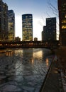 Side angle view of Chicago city night lights illuminated and reflected onto a frozen Chicago River. Royalty Free Stock Photo