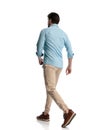 side and back view of casual young man walking on white background Royalty Free Stock Photo