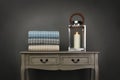 Side board table, candle and throws on grey background