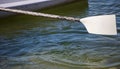 A side of boat and a white paddle ready to touch the sea. Close up view with details, empty, space for text.