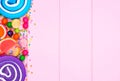 Side border of assorted colorful candies against pink wood Royalty Free Stock Photo