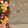 Side border of Christmas decor and treats over rustic wood