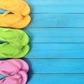 Side border row flipflops blue background wood beach deck square format Royalty Free Stock Photo