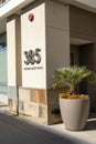 The side of a brown building with a large brown flower pot with lush green plants in Pasadena California