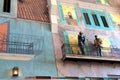 Side of building with railings, painted with a typical scene along the streets of New Orleans, 2016