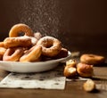 Side close up on a bunch of fresh homemade donuts with sugar and dark wooden background floor