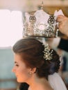 The side close-up portrait of the bride during the wedding coronation.