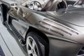 Side close up view from the back of modern roofless grey sport coupe car with mirror, hlem, chrome wheel disc and fuel Royalty Free Stock Photo