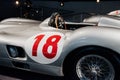 Side, close up view of grey retro sport coupe cabriolet, red number 18 painted on left door, with wooden steering wheel