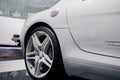 Side close up view of modern sport car with right white light alloy wheel and low-profile tire, chrome fuel tank cover Royalty Free Stock Photo