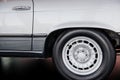 Side close up view of white retro car with white light alloy wheel and low-profile tire, chrome disk, arch above Royalty Free Stock Photo