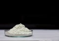 Side view of heap of white modified starch in glass ware isolated on black and gray background