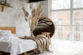 Side closeup view on spacious airy white eco style loft bedroom with bed,  mirror and pampas grass decoration Royalty Free Stock Photo