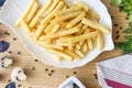 side dishes, second courses, French fries in a white plate on a wooden table with herbs and spices view from the top