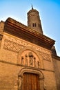 Side door on Calle San Blas and tower of the church of San Pablo in the neighborhood of el Gancho in Saragossa, Spain