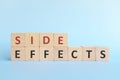 Side effects word on wooden blocks in blue background typography.
