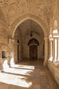 Side entrance with a decorative figure of a peacemaker on the wall and a bell on the floor to the side of the Chapel of Saint