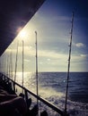 Side of Fishing Boat Charter in the Ocean with Poles at Sunset Royalty Free Stock Photo