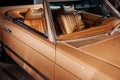 Side and front, close up view of beige retro cabriolet car leather interior and hood: steering wheel, rear mirror and Royalty Free Stock Photo