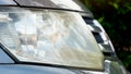 Side of front gray car close up on car headlights. Royalty Free Stock Photo