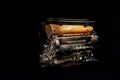 Side and front view of car detail: internal combustion engine with orange part isolated on the black background Royalty Free Stock Photo